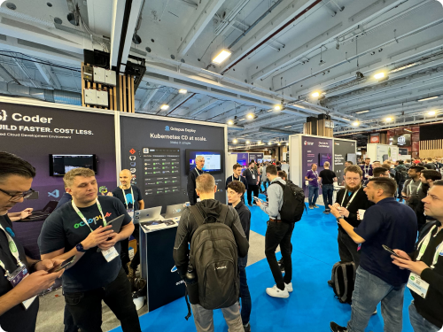 People talking at an event standing in front of a booth